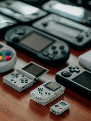 Collection of diverse retro handheld gaming consoles on a wooden surface, showcasing classic designs and nostalgia.
